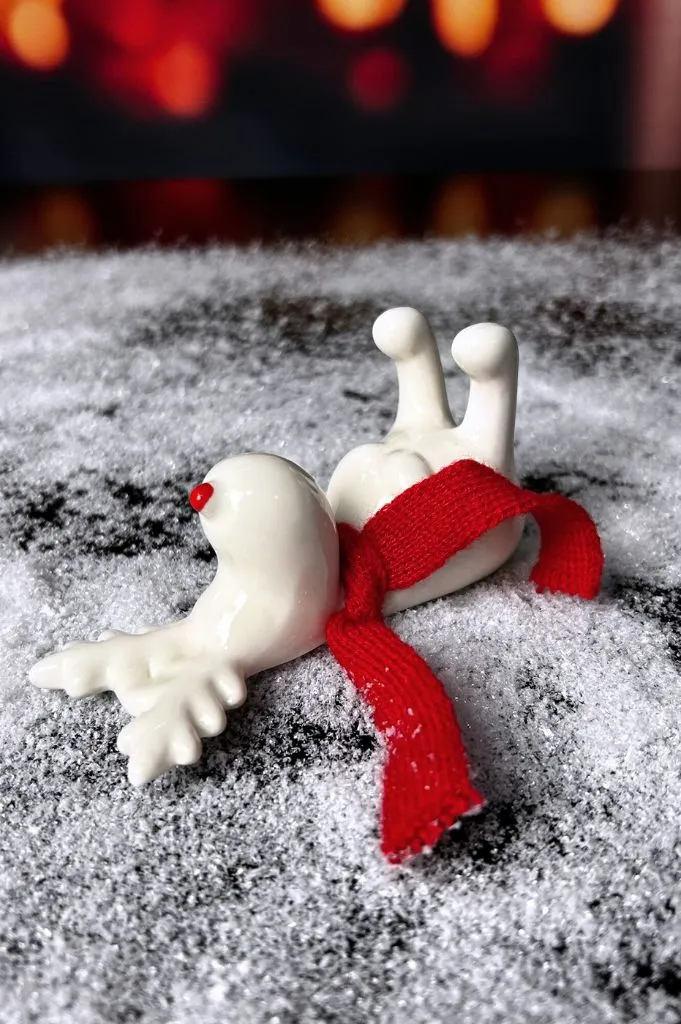 Rentier Rudolph liegend creme-weiß mit rotem Schal