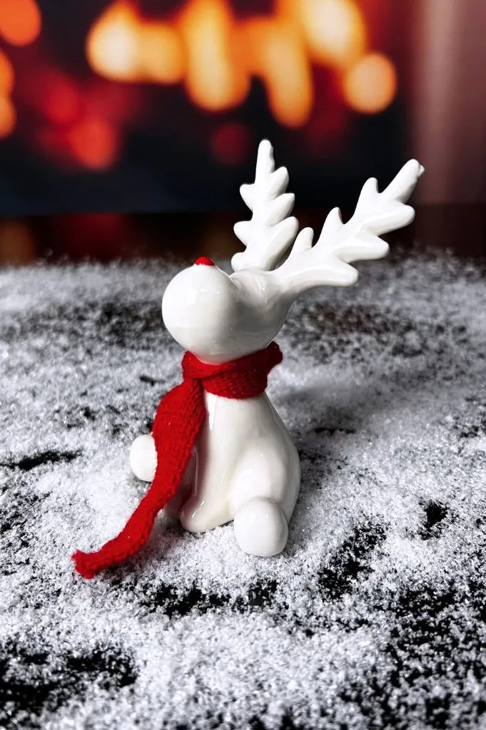Rentier Rudolph sitzend creme-weiß mit rotem Schal